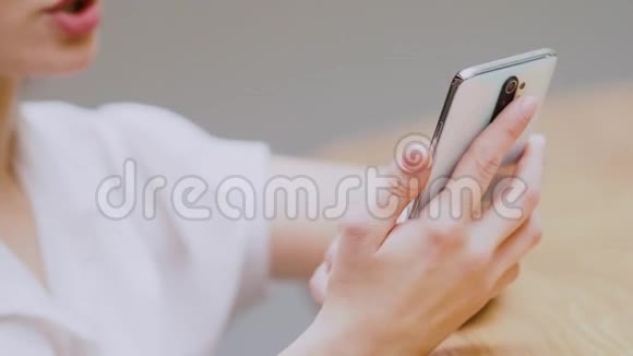 年轻的黑发女孩用智能手机交流信使的在线通信视频的预览图