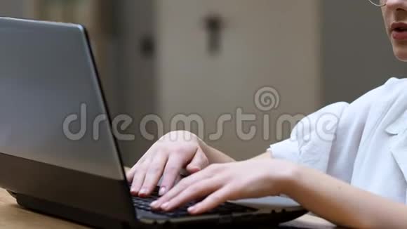 自由职业和远程工作戴眼镜的年轻女子在笔记本电脑上打信视频的预览图