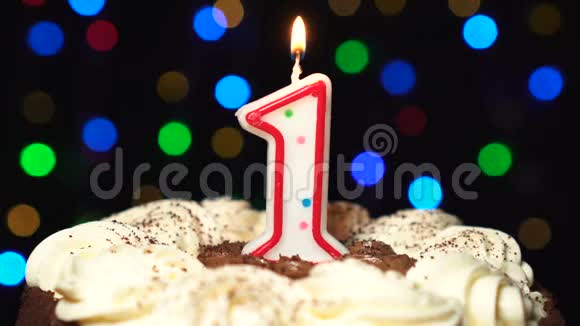 头上的第一个蛋糕一个生日蜡烛燃烧吹出在最后彩色模糊背景视频的预览图