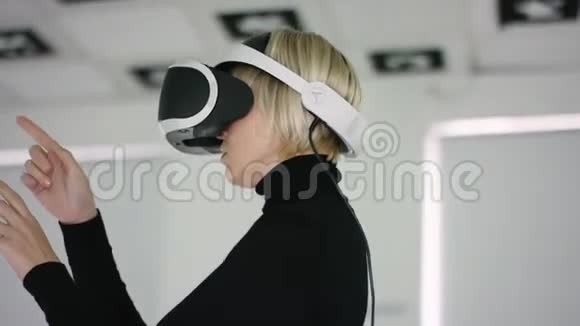 一个年轻女子在一个虚拟现实耳机中近距离拍摄她站在一个充满了视频的预览图