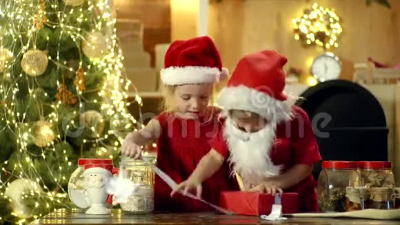 快乐可爱的孩子们打开圣诞礼物两个快乐的孩子女儿儿子妹妹和兄弟视频的预览图