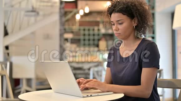 年轻的非洲女人手提电脑显示拇指向下视频的预览图