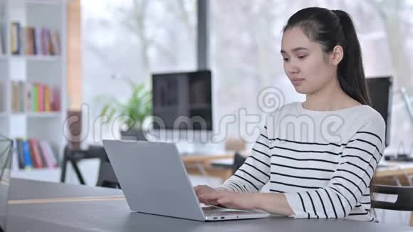 青年亚洲妇女使用办公室笔记本电脑竖起大拇指视频的预览图