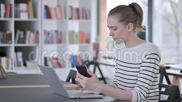 青年妇女使用图书馆笔记本电脑视频的预览图