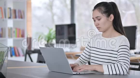 办公室有头痛的亚洲青年妇女使用笔记本电脑视频的预览图