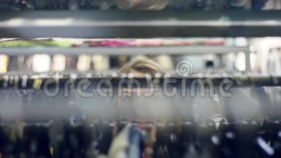 一位年轻迷人的女士正在商场的服装店里寻找新衣服微笑着视频的预览图