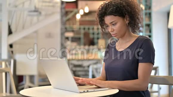 在咖啡厅使用笔记本电脑的专业非洲青年妇女视频的预览图