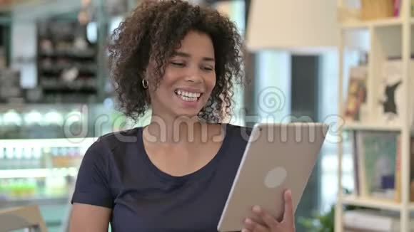 青年非洲妇女在平板上的视频聊天画像视频的预览图