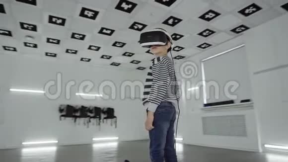 追踪弧线360度拍摄的一个小男孩戴着一个大大的白色耳机在虚拟现实中四处张望视频的预览图
