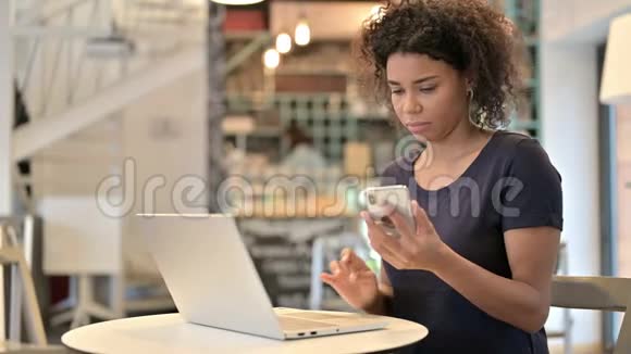 青年非洲妇女在咖啡厅使用笔记本电脑视频的预览图