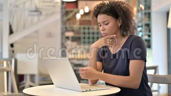咖啡屋里使用笔记本电脑的非洲年轻女性视频的预览图