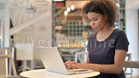 青年非洲妇女对咖啡厅笔记本电脑损失的回应视频的预览图