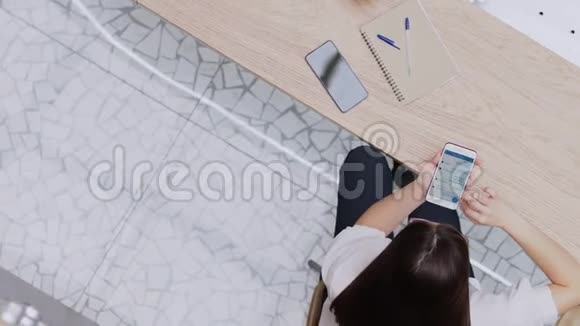 年轻的黑发女孩用智能手机交流信使的在线通信视频的预览图