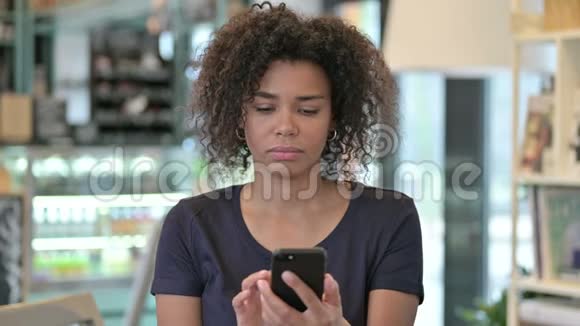 非洲青年妇女在智能手机上讲话的肖像视频的预览图