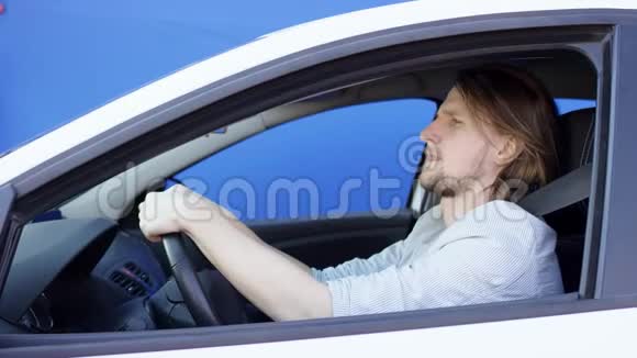 困乏的司机陷入交通堵塞年轻疲倦的人把头放在方向盘上布鲁内特先生视频的预览图