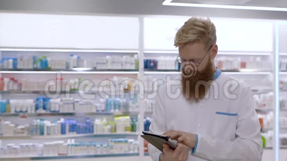 年轻的药剂师在药物的背景下使用药片视频的预览图