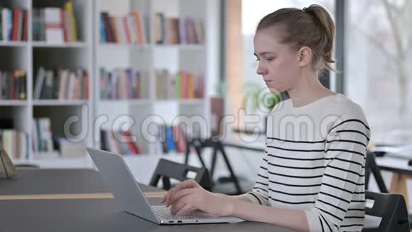 图书馆颈痛青年妇女手提电脑使用视频的预览图