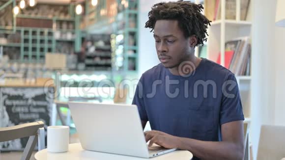 非洲男子关闭笔记本电脑和离开咖啡厅视频的预览图