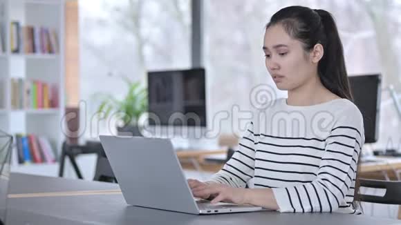 亚洲青年妇女在办公室使用笔记本电脑视频的预览图