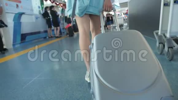 年轻的女旅行者带着手提箱穿过机场女人穿过停车场离开城市视频的预览图