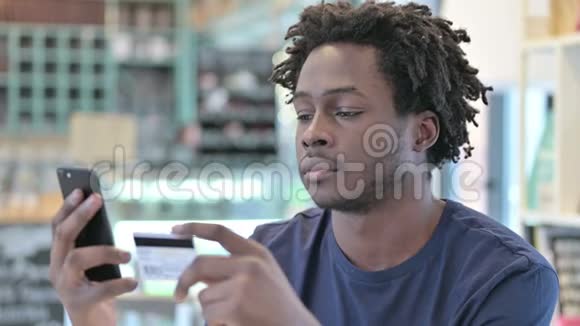 非洲男子在智能手机上的网上支付画像视频的预览图