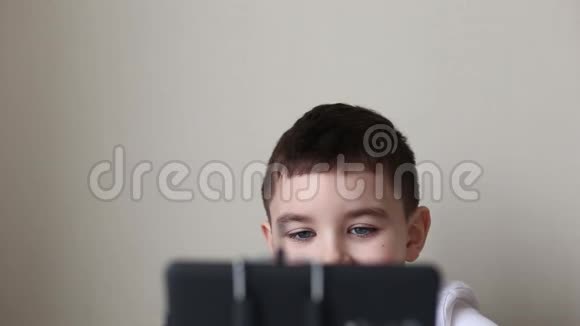 一个棕色头发的男孩从黑色智能手机后面偷看的金发眼睛视频的预览图