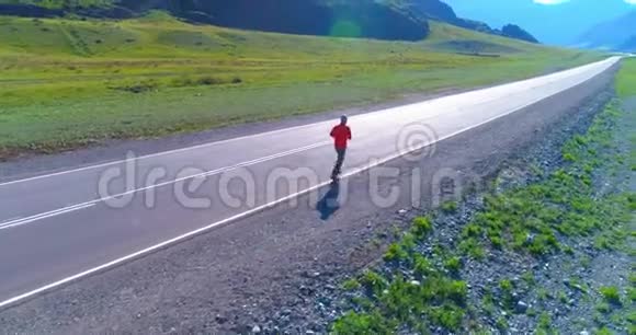 完美柏油路上运动男子前方低空飞行视频的预览图