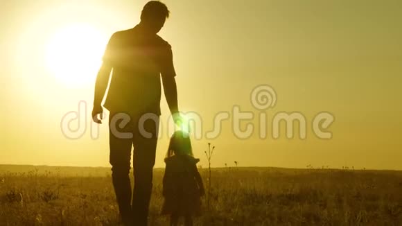 小女儿和爸爸牵着手在田野里走来走去孩子握着父亲手一家人晚上步行出城视频的预览图