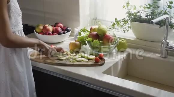 早上女性在厨房用手切苹果切片作为水果沙拉筹备工作视频的预览图