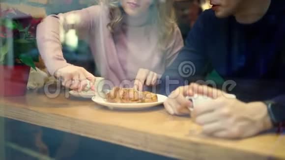 年轻漂亮的男人和女人在舒适的咖啡馆里约会一起喝咖啡和吃牛角面包视频的预览图