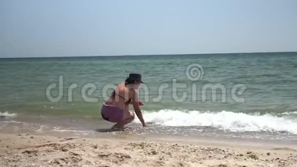 一个晒黑了的女人站在海边视频的预览图