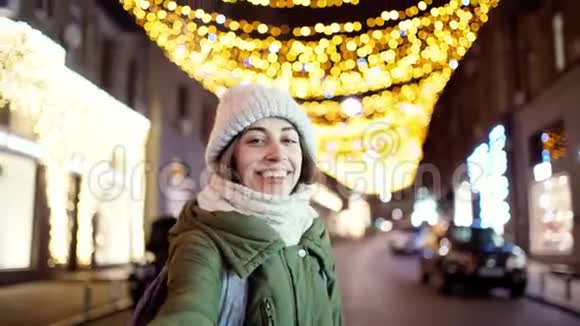 喜笑颜开的年轻女子穿着温暖的冬衣羊毛针织围巾和帽子的特写夜像视频的预览图