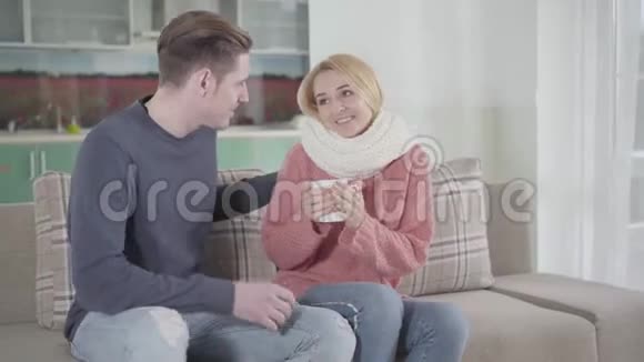 年轻的白种人男人一边爱抚妻子一边喝热饮料照顾生病妇女的丈夫视频的预览图