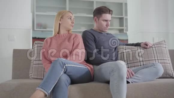 年轻的白种人女人推着男人肩膀给他一个小小的手指来和平年轻的争论家庭坐着视频的预览图