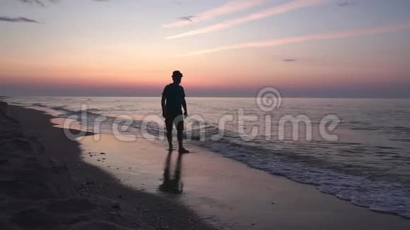 一个人在荒无人烟的海滩上平静地散步视频的预览图