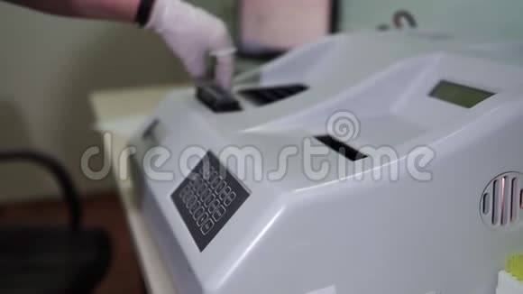 女实验室技术人员设置化验机进行血液分析视频的预览图