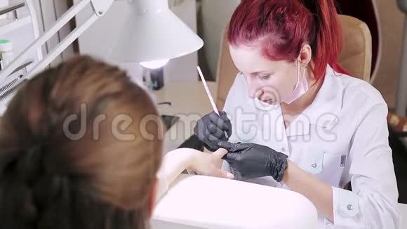 美容院的美甲师正在给病人的指甲涂凝胶视频的预览图
