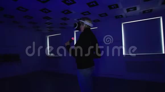 在playstation虚拟现实耳机里一位年轻女子正和控制器在空荡荡的游戏室里挥手视频的预览图