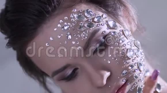 一位年轻美丽的女人用透明水晶做的时尚画像视频的预览图