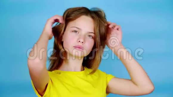 穿黄色T恤的快乐少女双手直发摆姿势看着镜头视频的预览图