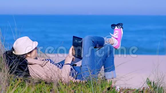 躺在沙滩上和网上聊天的女人视频的预览图