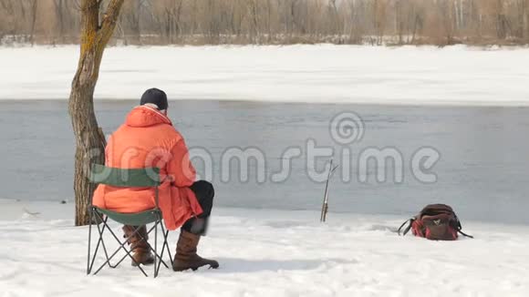 岸上的一个人在冬天钓鱼一个远离人们的风景如画的地方水流在一个视频的预览图