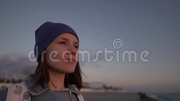 一个旅游女孩欣赏海滩上的日落浪漫的场景剪影视频的预览图