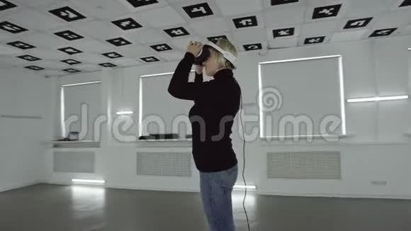 年轻女子戴着虚拟现实耳机双臂上下移动空着耳机取下视频的预览图