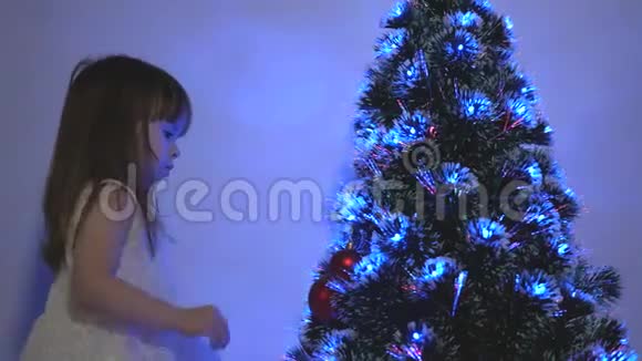 孩子们用圣诞球装饰圣诞树特写镜头小孩在孩子们房间里玩圣诞树视频的预览图
