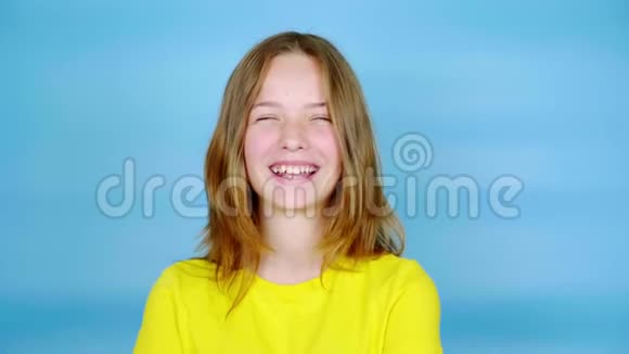 穿黄色T恤的快乐少女正在笑着看着镜头视频的预览图