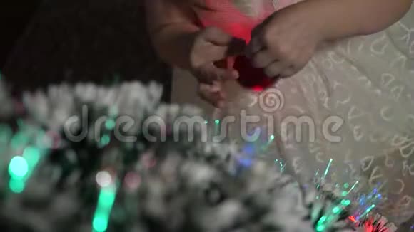 孩子们用圣诞球装饰圣诞树小孩子在孩子们房间里玩圣诞树女儿视频的预览图
