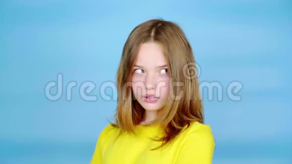穿着黄色T恤的少女正看着相机摇着头视频的预览图