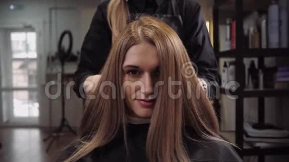 理发师展示了他工作的结果美发沙龙里的美女视频的预览图