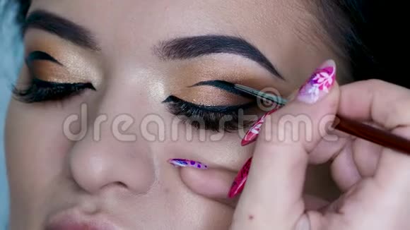 美容院化妆师做晚妆美丽的眼睛与金色眼影视频的预览图